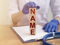 NAME word on wooden block in doctor hand