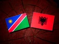 Namibian flag with Albanian flag on a tree stump isolated