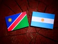 Namibian flag with Argentinian flag on a tree stump isolated