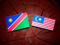 Namibian flag with Malaysian flag on a tree stump isolated