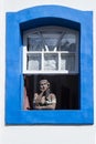 Namoradeira is a woman looking at street in the window. Brazilian handicraft made with adobe