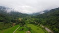 Nan, Thailand, Small hut in green rice terrace near stream. Village in valley with fog and mist.