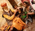 Elderly man paints symbols using gold paint onto the forehead of