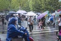 ItÃ¢â¬â¢s raining in the morning, and pedestrians walking through the road pass by the intersection.