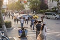 Sunset city scenery, pedestrians, traffic flow.