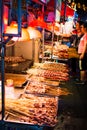 NANNING, CHINA - JUNE 9, 2017: Food on the Zhongshan Snack Street, a food market in Nanning with many people bying food and