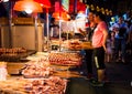 NANNING, CHINA - JUNE 9, 2017: Food on the Zhongshan Snack Street, a food market in Nanning with many people bying food and