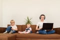 Nanny with laptop to surf Internet while kids play with phones. Bad nanny concept