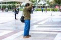 Nantong City /Asian male photographer taking photos with DSLR camera in city