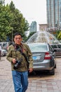 Nantong City / China asian retired male tourist walking around in city with DSLR camera
