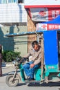 Nantong City / China - October 4, 2011 : One Asian China Chinese man on electric trishaw, head turned to back looking out for