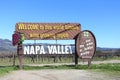 NAPA VALLEY CALIFORNIA - FEB 6,  2022: Wooden welcome sign for Napa Valley set before rows of grape vines. Napa Valley is widely Royalty Free Stock Photo