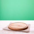 Napkin and board for pizza on wooden desk. Canvas, dish towels on white wooden table and green background top view mock