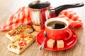 Napkin, cezve, khachapuri with tomato and basil, cup with coffee, sugar, spoon on saucer on wooden table Royalty Free Stock Photo