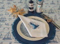 Napkin with an embroidered beacon on a plate. Blue color, marine style, table setting Royalty Free Stock Photo
