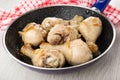 Napkin, fried chicken legs in frying pan on table