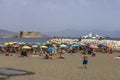 People relaxing on the Mappatella Beach by the Tyrrhenian Sea, Castel dell\'Ovo in the background, Naples,