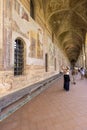 Cloister Santa Chiara, view of corridor under arcades and decorated colorful frescoes, Naples, Italy