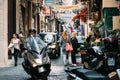 Naples, Italy. Man Riding On Scooter At Vico Lungo Del Gelso Street. Traffic On Famous Narrow Street.