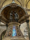 Naples, Italy - September 28, 2023: Part of the baptismal font with Jesus and John the Baptist pointing upwards to the Holy Spirit