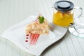 Napoleon cake decorated with a spiral of red chocolate, mint and berry jam on a white plate against a background of Royalty Free Stock Photo