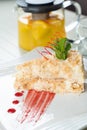 Napoleon cake decorated with a spiral of red chocolate, mint and berry jam on a white plate against a background of Royalty Free Stock Photo