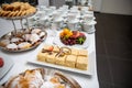 Napoleon cake decorated with strawberry and chocolate chips. croissants, cupcakes and fruits on a buffet table