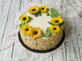 Napoleon cake with vanilla cream, decorated with buttercream flowers - sunflowers. Vintage style. Wooden background,lace