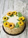 Napoleon cake with vanilla cream, decorated with buttercream flowers - sunflowers. Vintage style. Wooden background,lace