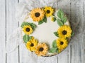 Napoleon cake with vanilla cream, decorated with buttercream flowers - sunflowers. Vintage style. Wooden background,lace