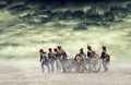 Napoleonic soldiers marching in open plain land with dramatic clouds., pulling a cannon.