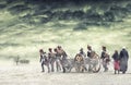 Napoleonic soldiers and women marching and pulling a cannon in plain land, countryside with stormy clouds. Soldiers going towards