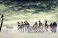 Napoleonic soldiers and women marching and pulling a cannon in plain land, countryside with stormy clouds. Soldiers walking