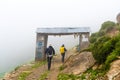 Backpackers entering Nar village on foggy trekking path in Annapurna Conservation Area, Nepal Royalty Free Stock Photo