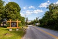 NARAMATA, CANADA - JULY 5, 2020: asphalt road in small tonw with sign green trees and blue sky