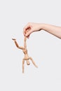 A narcissistic parent. A wooden mannequin in the hand of an adult who tortures and abuses her. Metaphor with domestic violence