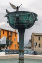 Narni, Italy - July 27, 2019: Central fountain, pigeons and water, medieval city: a typical old street. Vertical photo Terni,