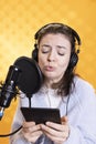 Narrator glowers, portraying character, recording audiobook, studio background