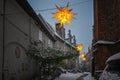 Narrow alley in the historic old town of Lubeck illuminated with yellow Moravian stars (German Herrnhuter Stern) Royalty Free Stock Photo