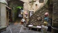 Narrow alley of old city with tourist goods. Action. Meager open shop with souvenirs located in nook between stone walls