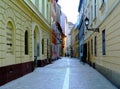 Narrow alley in old downtown area in Gyor, Hungary with arched windows and cobblestone