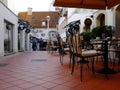 narrow alley and passage way with street terrace, tables and chairs