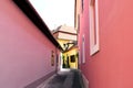 Narrow alley with pink stucco facade and windows. Royalty Free Stock Photo