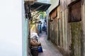 Narrow alley in the slums. Poor neighborhood. Marginal living standards. Garbage, old things and bicycles in the area