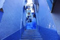 Narrow alley with a staircase in Chefchaouen city in vibrant blue color - suitable for a wallpaper Royalty Free Stock Photo