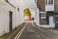 Narrow alley with typical English buildings on the right side of Royalty Free Stock Photo