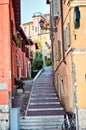 Narrow ancient street flowers sidewalk stone steps colorful facade Italy center Verona
