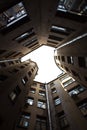 Narrow buildings well in Saint-Petersburg with the sky above the roofs. Below view.