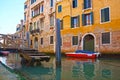 Narrow canal with boats in Venice, Italy