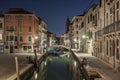 Narrow canal with boats and vintage houses at dusk. Venice city at night Royalty Free Stock Photo